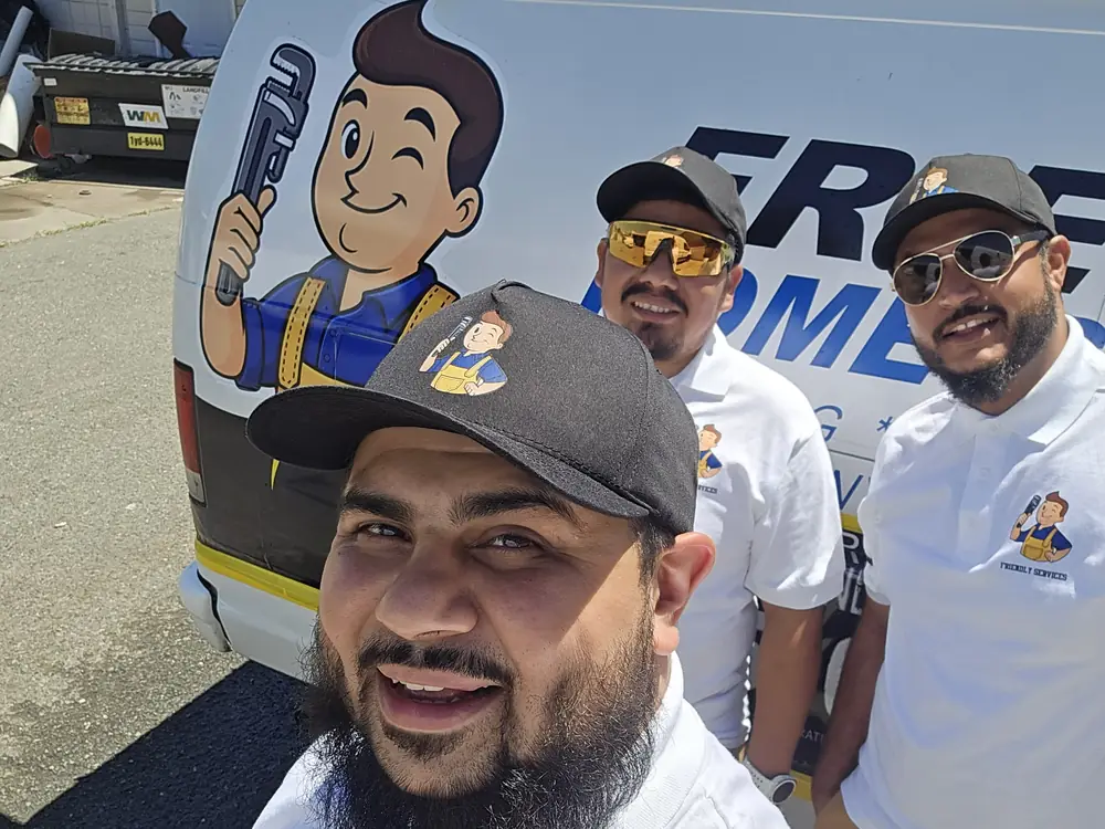 Ahmad, Elias and Robby of Friendly Services in front of a company van