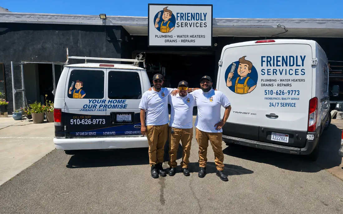 The Friendly Services team outside the Hayward shop with two company vans